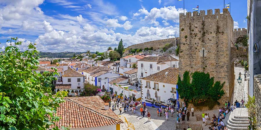 Cityscape of the town with medieval houses, stone wall and the Albarra tower. Obidos is a medieval town still inside castle walls.