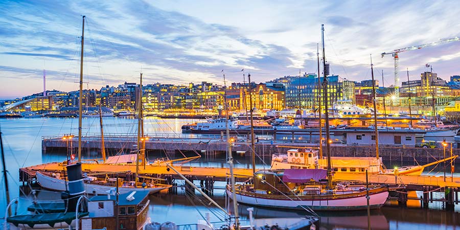 Boast at Oslo’s harbour, with the illuminated city in the distance.
