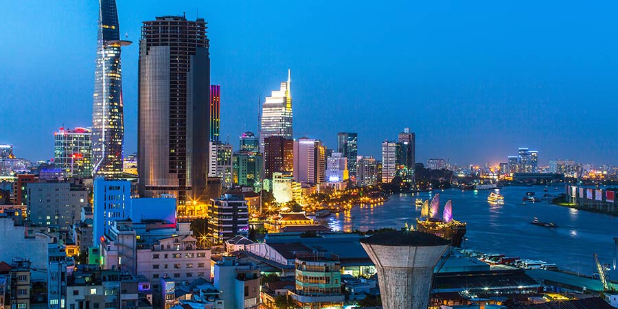 Ho Chi Minh City is full of life and many of the buildings and boats passing by are lit up at night.