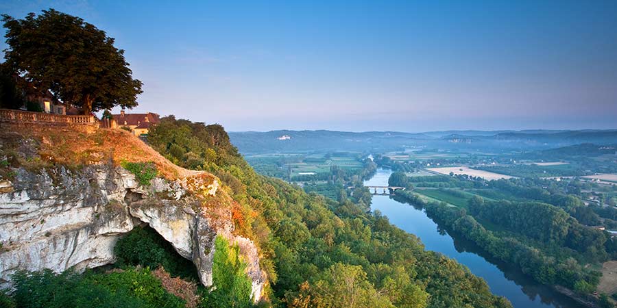 A scenic view of the Dordogne river from Domme on a bright morning.