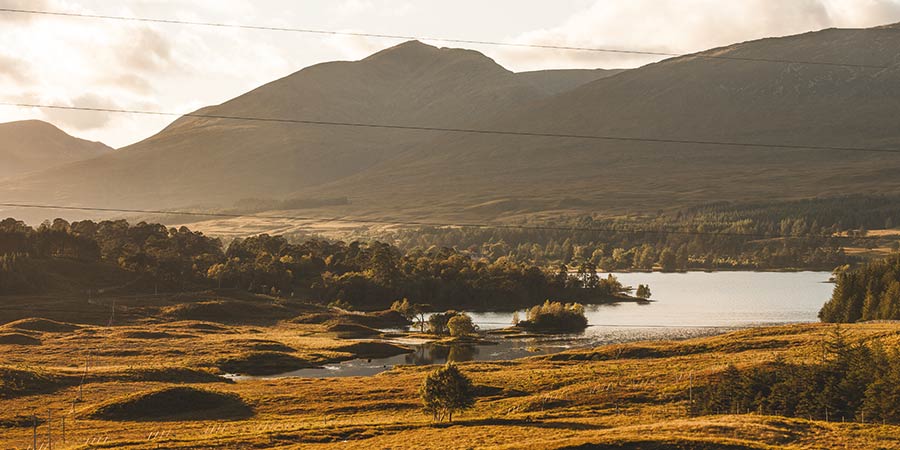 The dramatic Scottish landscape features glittering lochs, rolling hills and lush greenery.