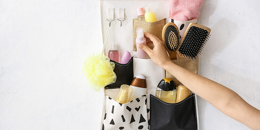 A hanging toiletries bag, full of hairbrushes, shampoo and other items.
