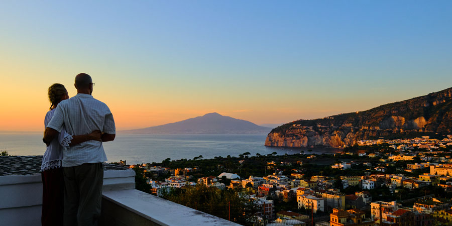 Two customers view Mount Vesuvius from a balcony.